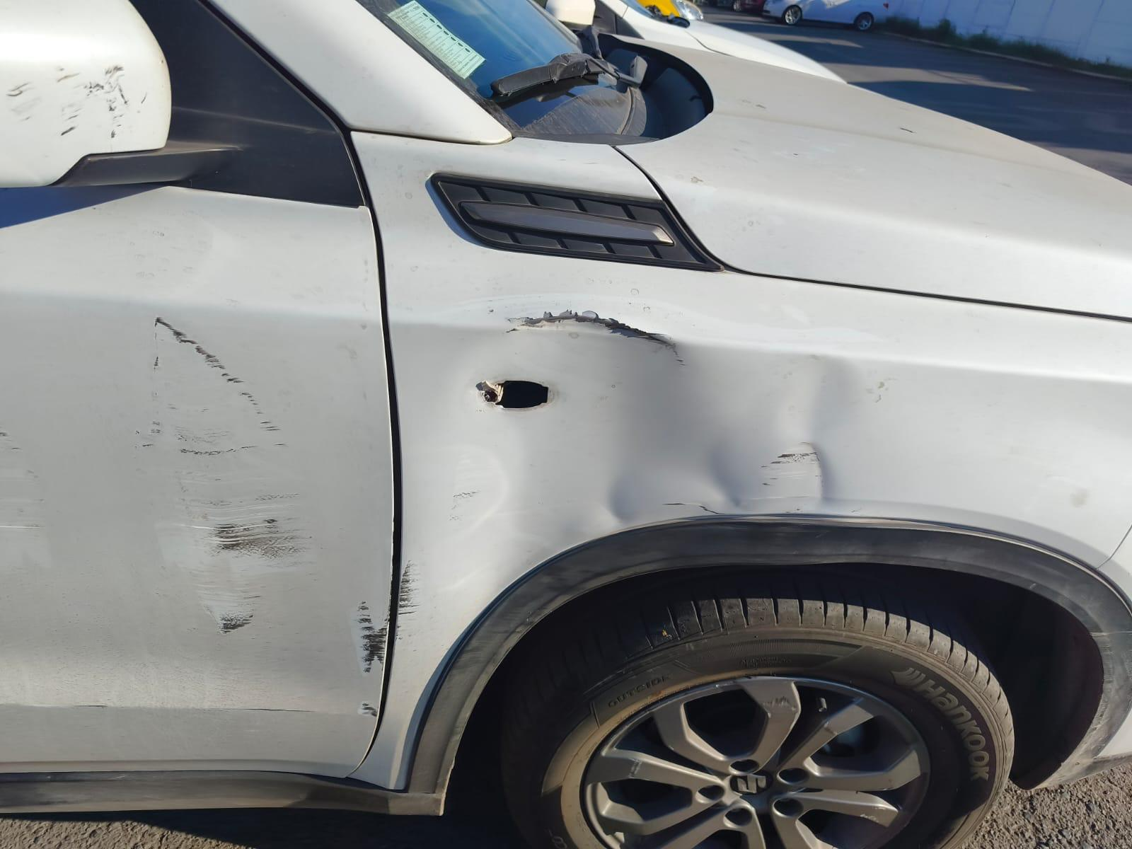 Daño en costado de SUV blanca antes de la reparación